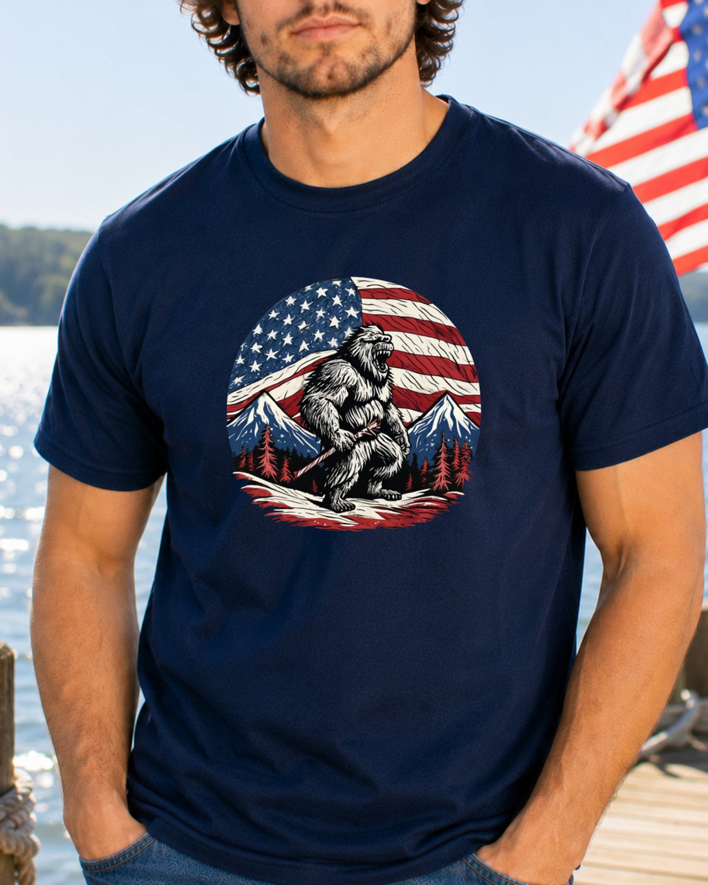 Bigfoot wearing a loincloth stands in front of an American flag and mountains.