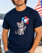 Gray kitten in bowtie holding patriotic balloons on navy t-shirt.