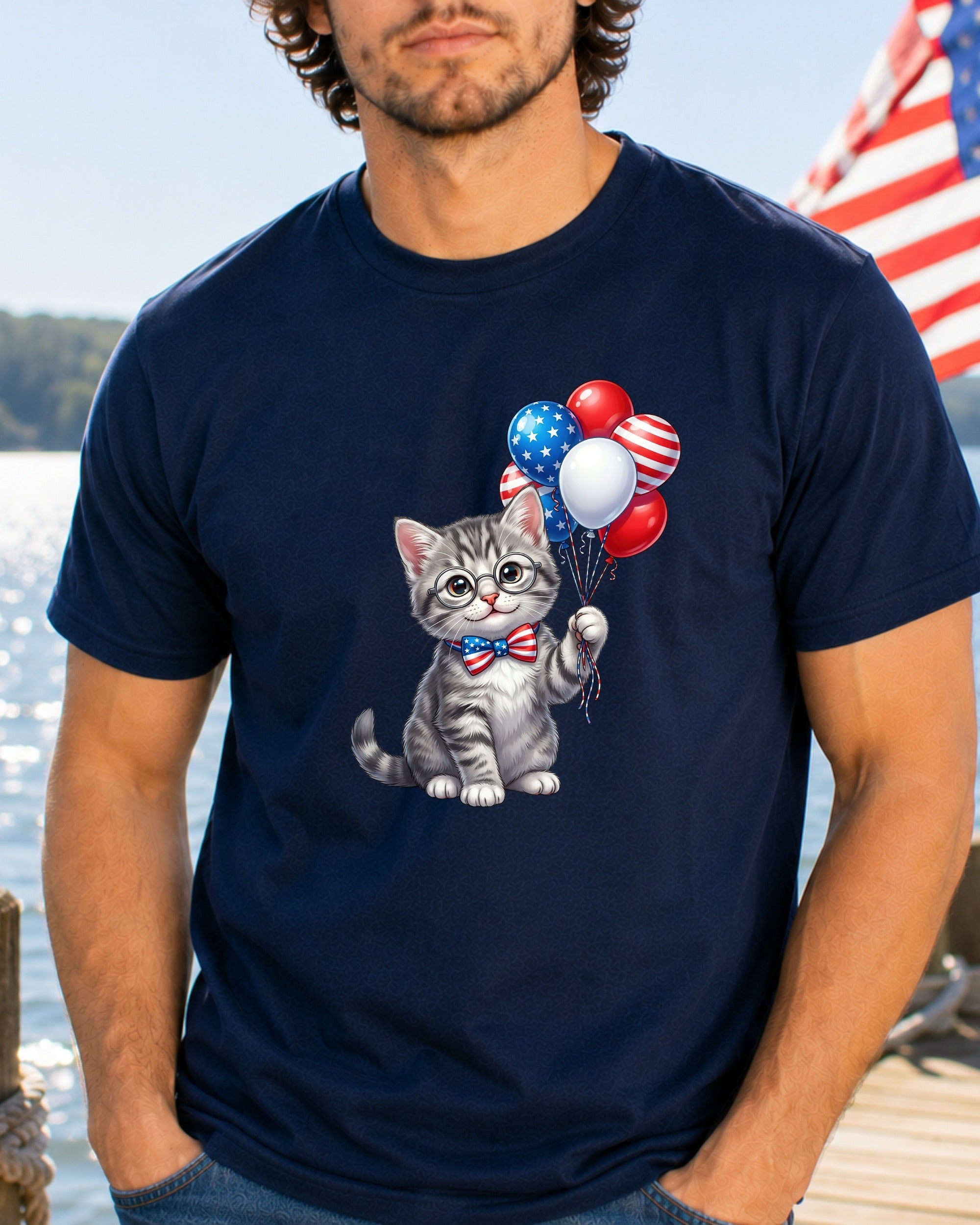 Gray kitten in bowtie holding patriotic balloons on navy t-shirt.