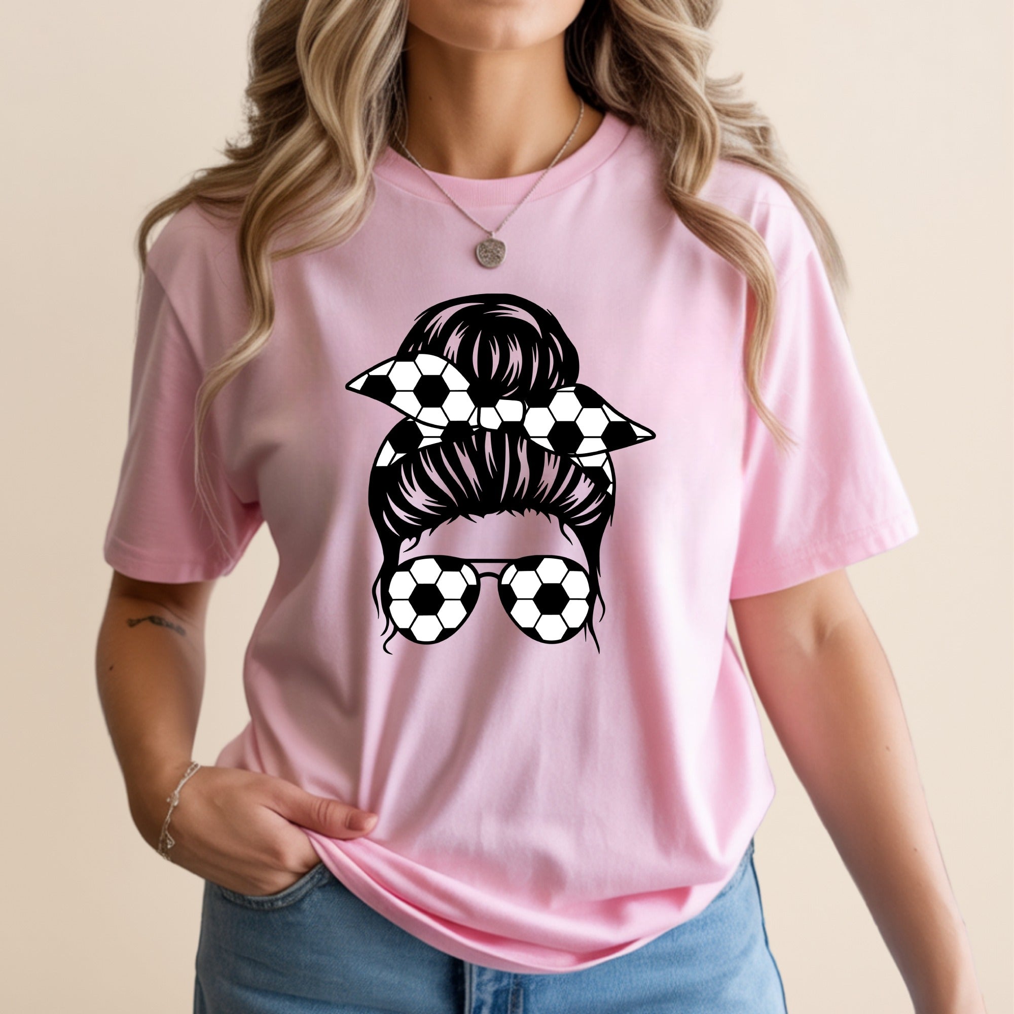 Pink t-shirt with graphic of messy bun hair and soccer ball sunglasses.