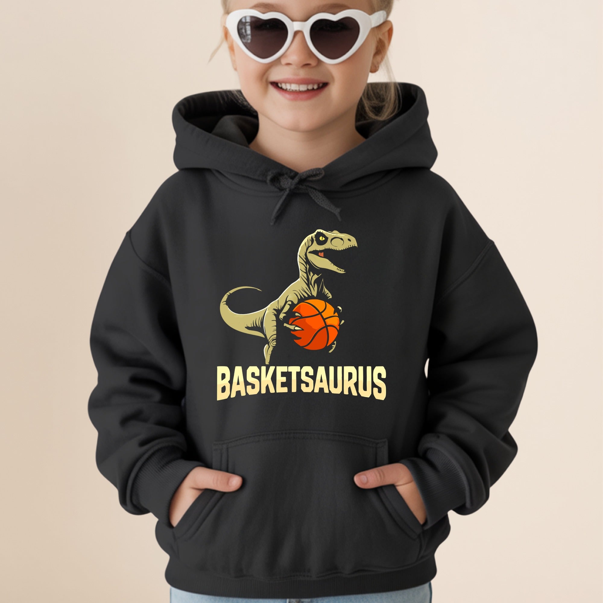 Black hoodie with a smiling child wearing heart sunglasses and a dinosaur graphic.