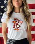 White t-shirt with cartoon duck wearing sunglasses, scarf, and holding an American flag.