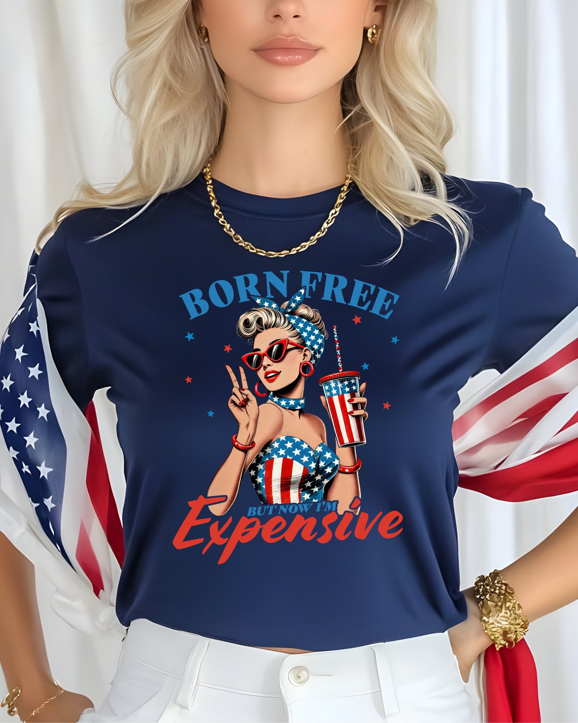 Woman in shirt with "Born Free But Now I'm Expensive" and American flag design.