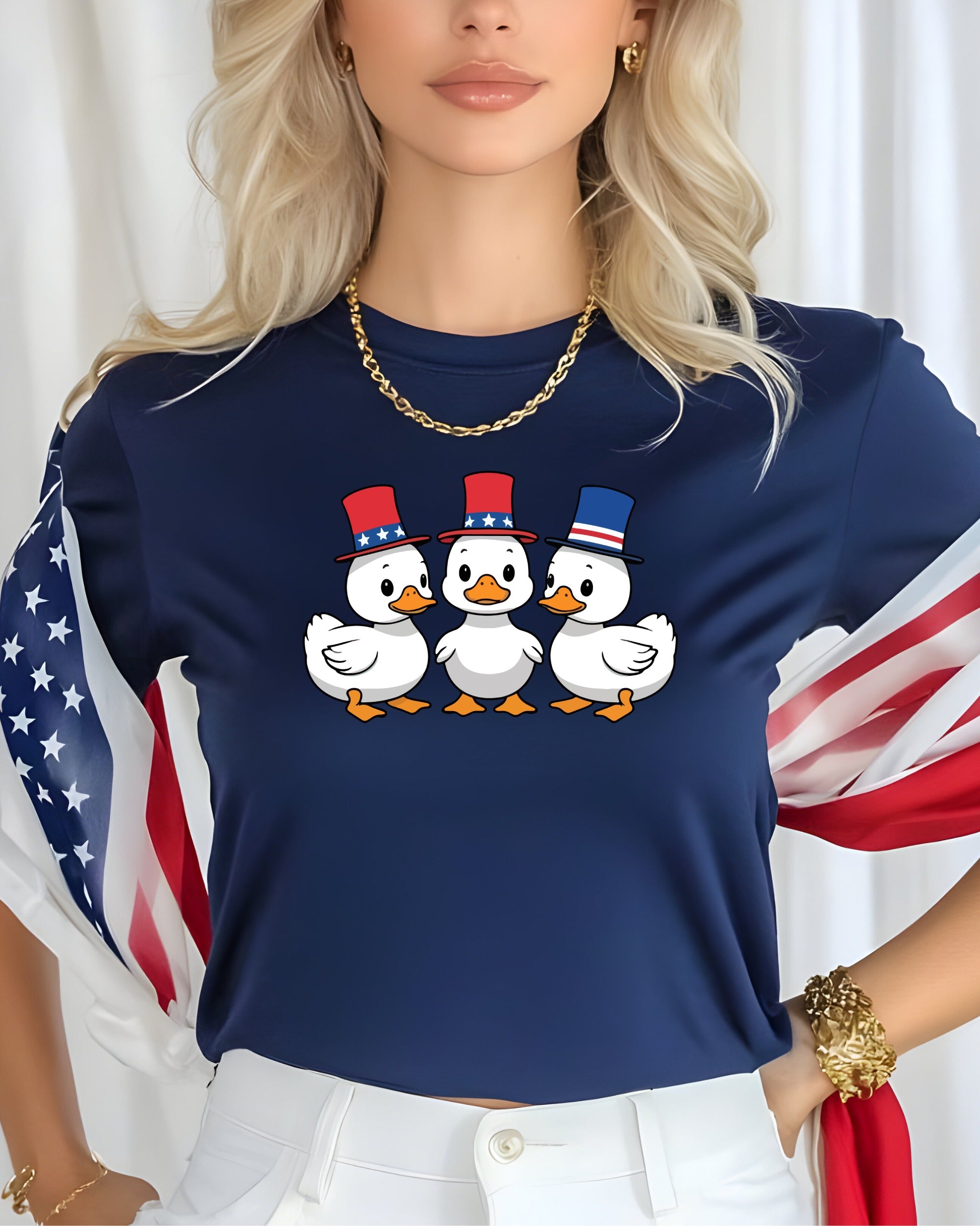 Three cartoon ducks wearing patriotic hats on a dark blue t-shirt.