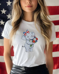 White t-shirt with a cartoon elephant holding a bouquet of flowers, with US flag in background.