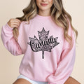 Pink sweatshirt with a black maple leaf design with "Canada" in the center.