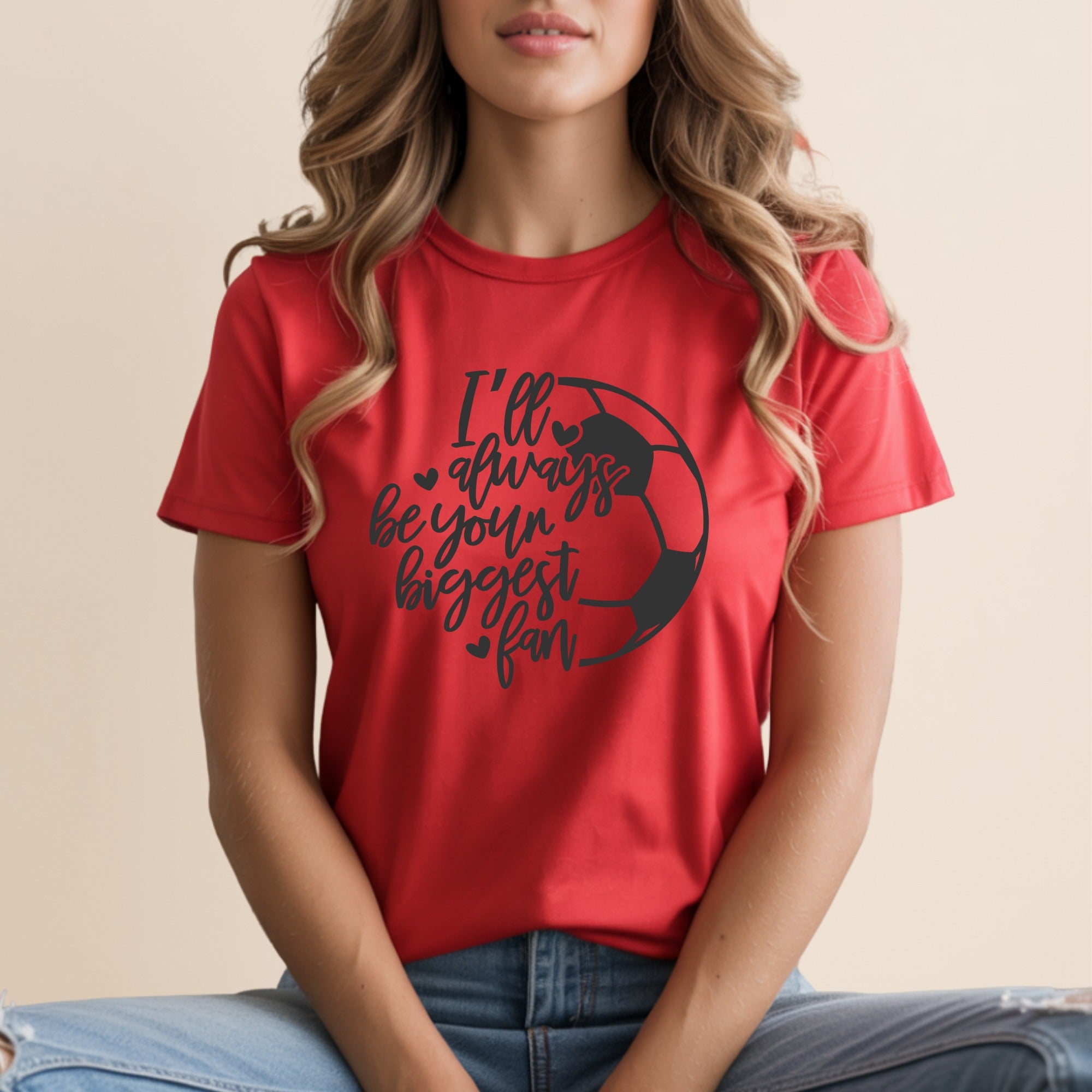 Red t-shirt with black text and soccer ball graphic: "I'll always be your biggest fan."