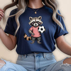 Cartoon raccoon in pink shirt and plaid shorts holding a soccer ball.