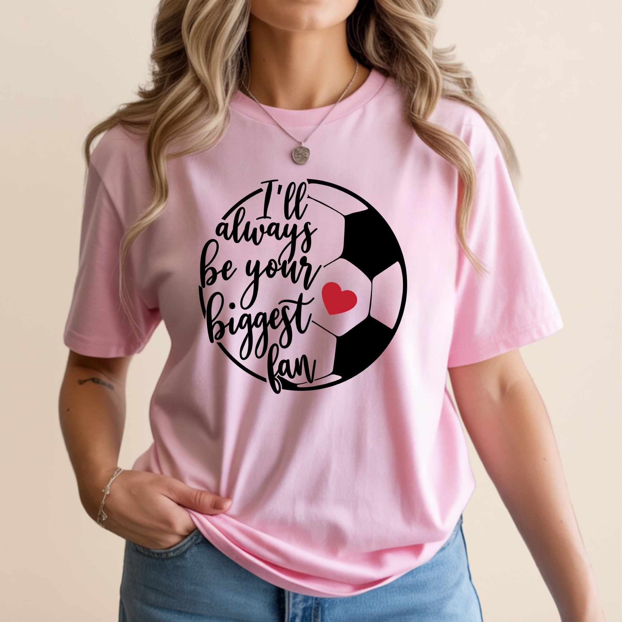 Pink t-shirt with a graphic of a soccer ball and "I'll always be your biggest fan" text.