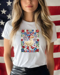 White t-shirt with patriotic duck graphic and American flag background.